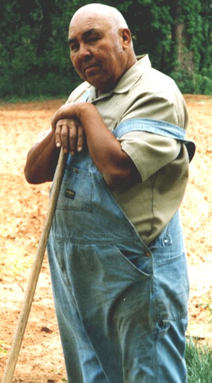 Bud stands leaning against a shovel
